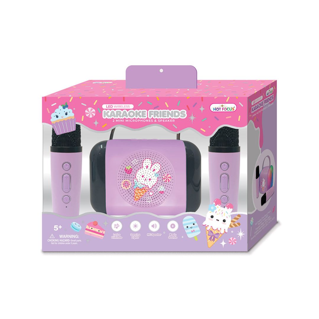A children's karaoke toy set in its retail packaging, featuring a lavender and pink portable speaker, two matching microphones, and a decorative front window display.