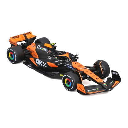 A 1:12 scale model of a black and orange Formula 1 race car, featuring sponsor logos like Chrome and OKXX, on a clean white background.