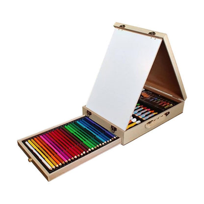 A wooden folding art set box shown open on a white background, with a large white drawing board on the outside and a drawer pulled out below containing many colored pencils and drawing tools.