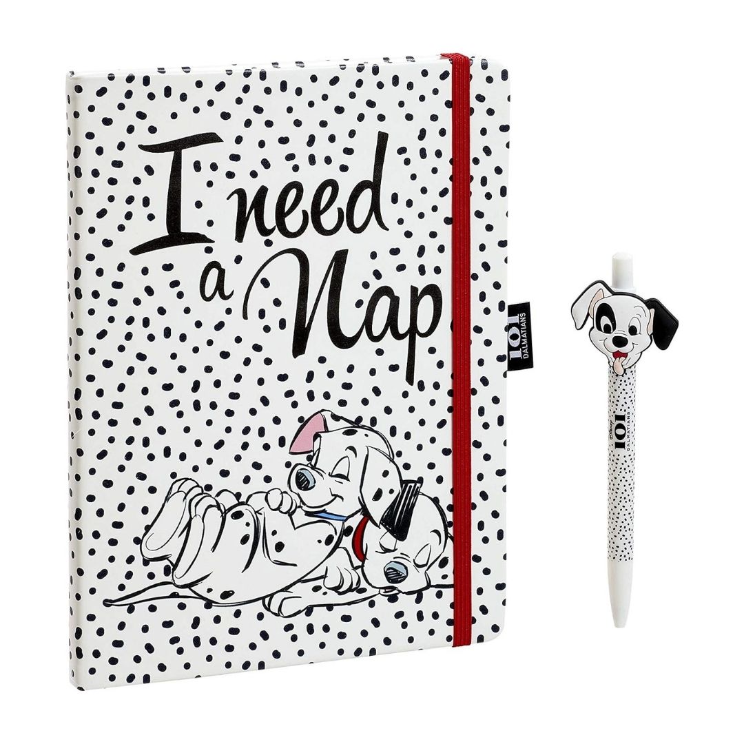 A notebook with a white cover covered in black polka dots, featuring the text 'I need a Nap' and a cartoon Dalmatian illustration, shown alongside a matching pen with a Dalmatian character on a white background.