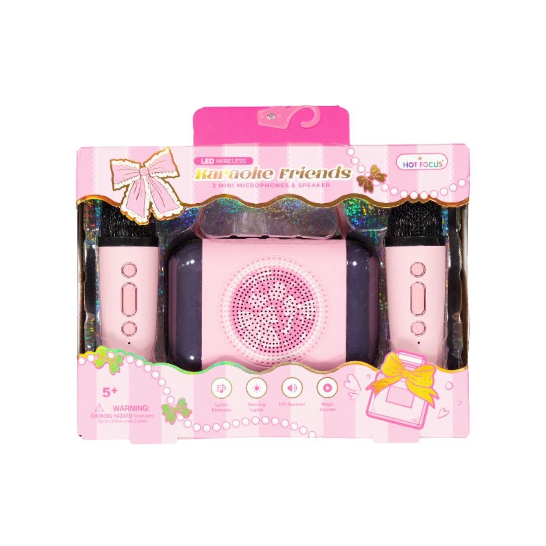 A pink toy karaoke set in its original retail packaging, featuring a central pink speaker-like unit, two matching pink controllers, and decorative box graphics with the text 'Karaoke Friends' and 'HOT FOCUS'.