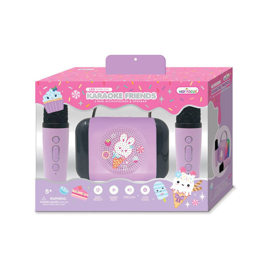 A children's karaoke toy set in its retail packaging, featuring a lavender and pink portable speaker, two matching microphones, and a decorative front window display.