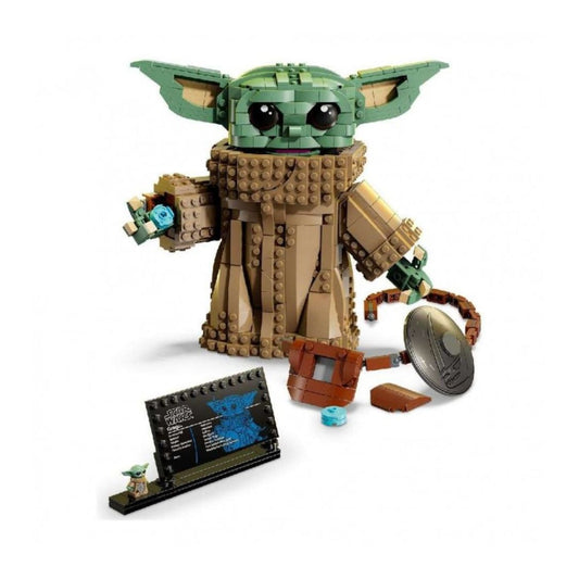 LEGO Star Wars The Child (Grogu) building set featuring a green brick-built Grogu figure with large ears, a tan robe, and accessories including a small blue lightsaber, brown armor pieces, a round gray shield, and a display stand on a white background.