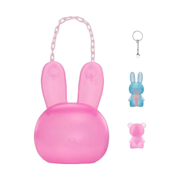 A pink bunny-shaped translucent bag with long ears, a chain handle, and a small keychain shown beside it on a white background. Two smaller bunny keychains are displayed on the right, one blue and one pink.