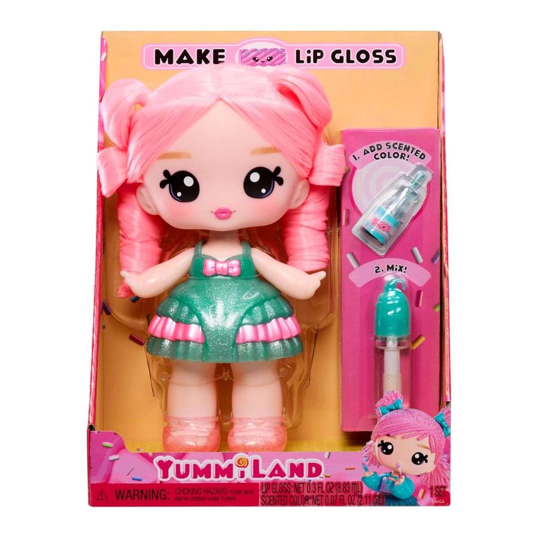 Yummi Land doll with pink hair in a green and pink dress, shown in its retail packaging with a lip gloss applicator and colored liquid inside a pink box.