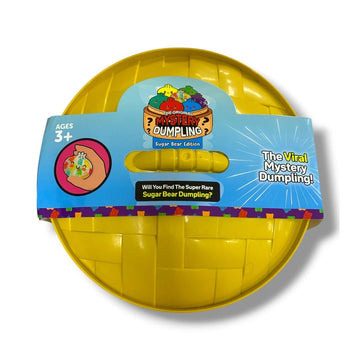 A yellow spherical toy labeled 'Mystery Dumpling' on a blue cardboard hanger, photographed on a white background.