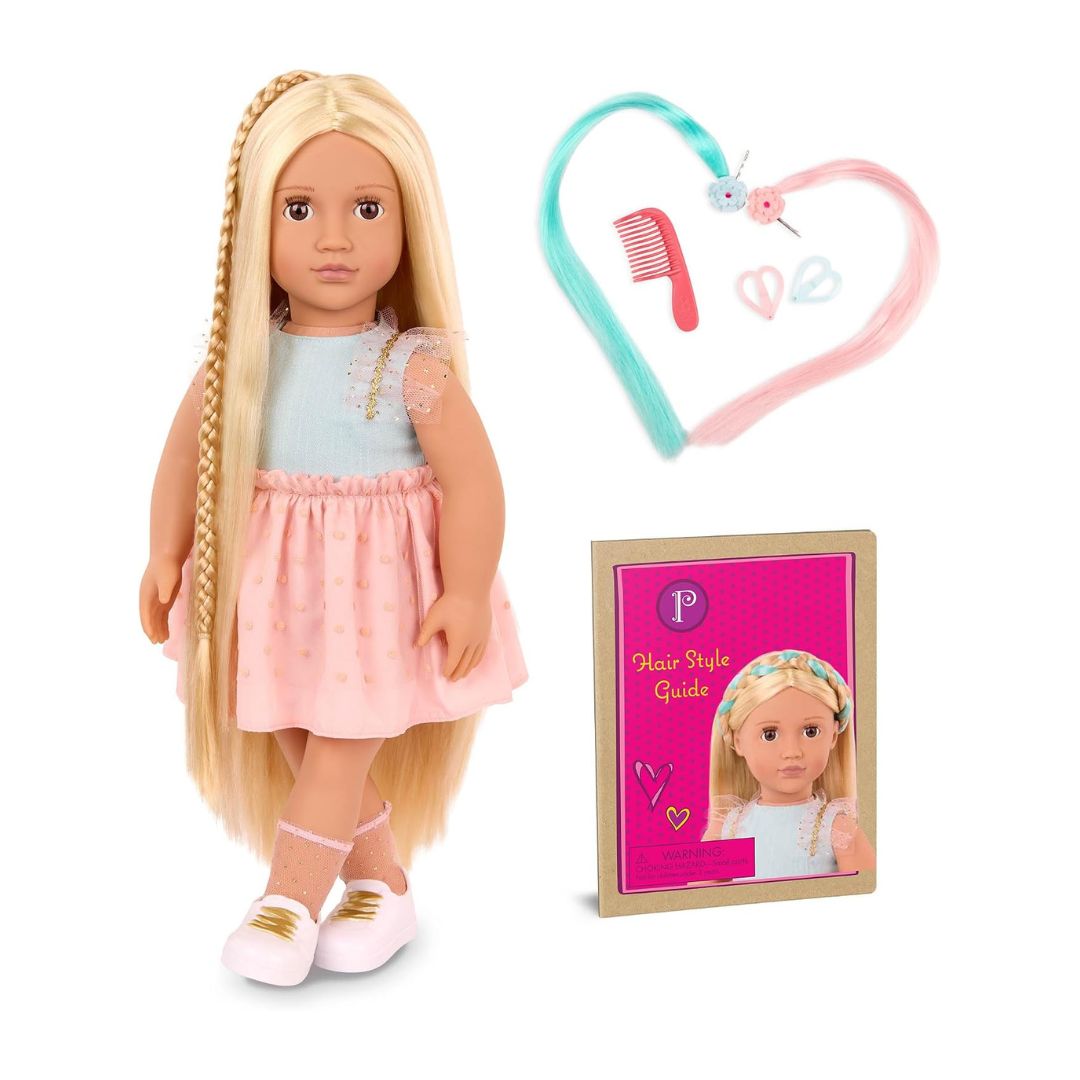 An 18-inch doll with long blonde hair styled in a braid, wearing a light blue top and pink skirt, shown with a hair styling accessory set and a 'Hair Style Guide' booklet on a white background.