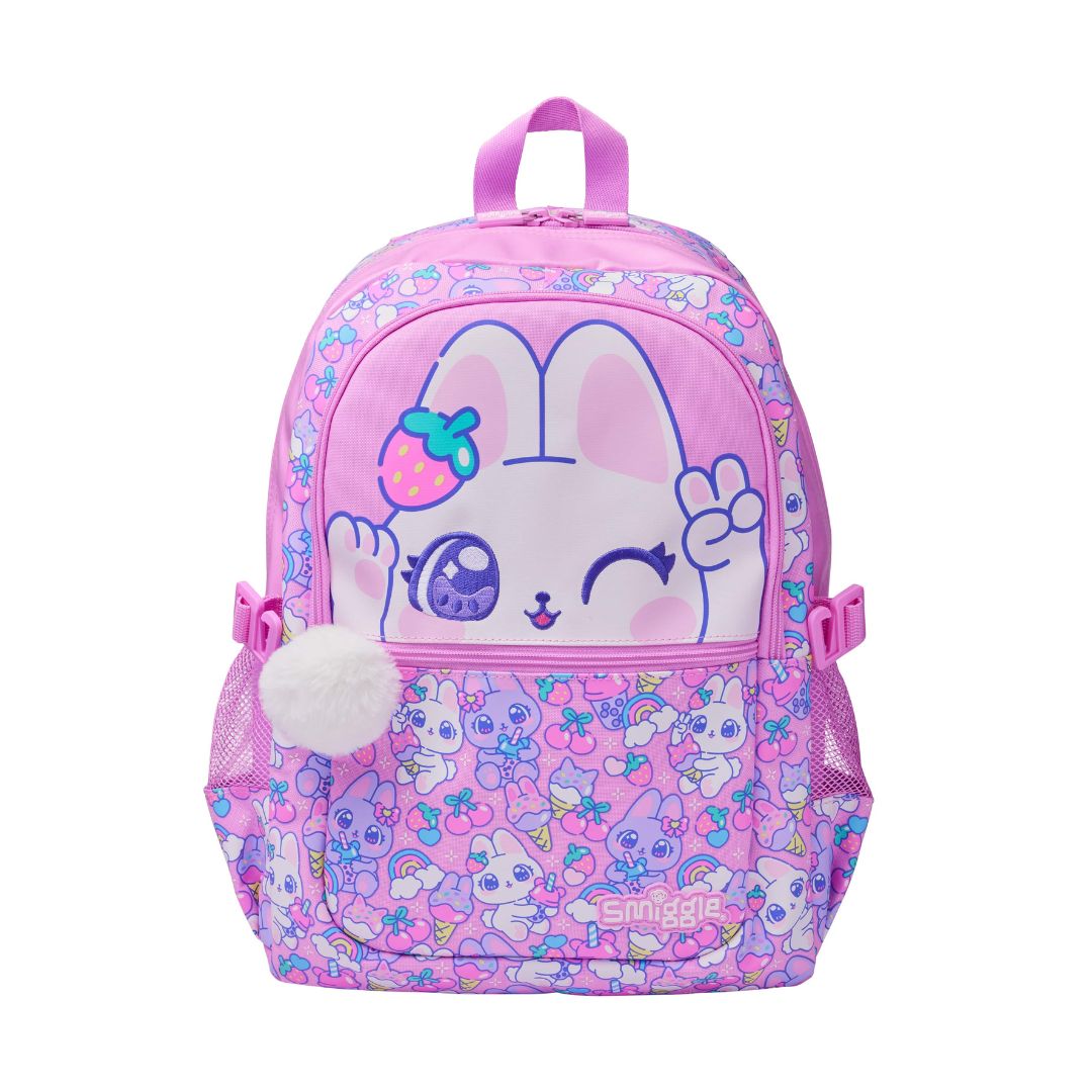 A pink children's backpack featuring a cute cartoon bunny face on the front pocket, surrounded by pastel floral patterns. The backpack has a top handle, side mesh pockets, and a white pom-pom charm.