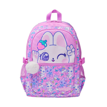 A pink children's backpack featuring a cute cartoon bunny face on the front pocket, surrounded by pastel floral patterns. The backpack has a top handle, side mesh pockets, and a white pom-pom charm.