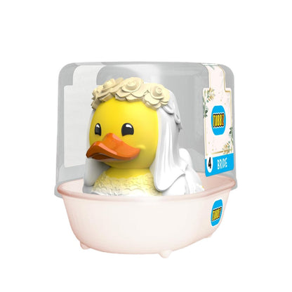 A yellow rubber duck dressed as a bride sitting in a pale pink bathtub, packaged in a clear plastic clamshell with a printed product label on the right side.
